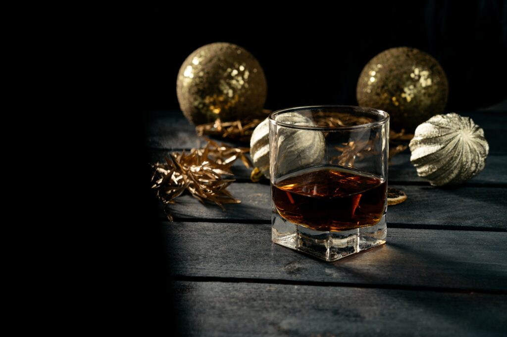 Glass with whiskey with christmas decorations